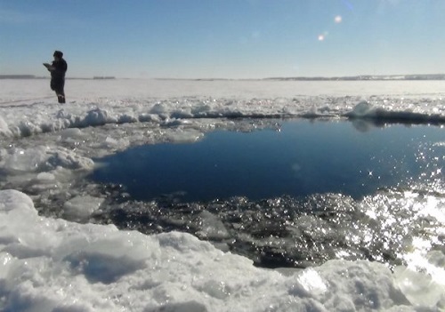 Russian soldier guards hole in lake where meteor hit